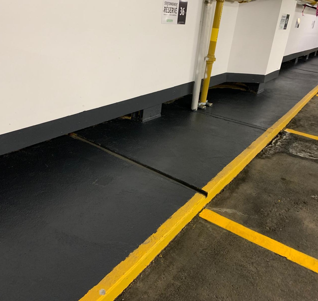 Parking wall with dark finished base and yellow curb line